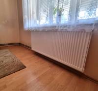 A room with a radiator under the window and a curtain in a family house.