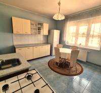 Kitchen in a family house with a dining table, kitchen unit, and electric stove.