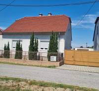 A family house on Riadok in Malacky with a red roof, a front garden, and a wooden gate.
