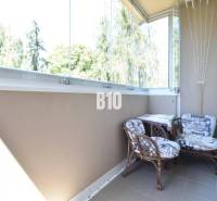 Glazed balcony with two chairs in a 3-room apartment with a nice view.