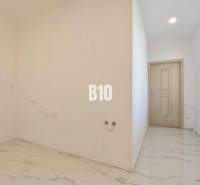 White wall and tiled floor in a 3-room apartment, empty room.