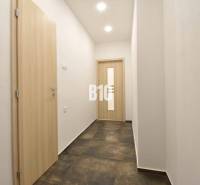 A corridor with white walls and doors in a 3-room apartment.