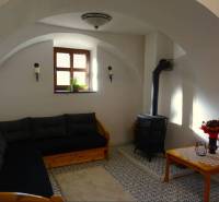 Interior of a family house with a sofa, stove, and decorative table.