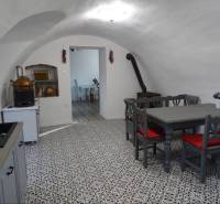 Interior of a family house with a vaulted ceiling, tiled floor, and dining table.