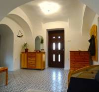 Interior of a family house with arched ceilings, wooden furniture, and patterned flooring.