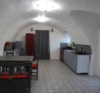 A kitchen in a family house with a vaulted ceiling, a red refrigerator, and patterned flooring.