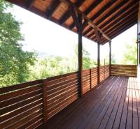 Wooden terrace of the cottage in Bytča with a view of the surrounding greenery.