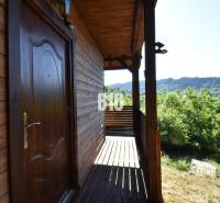 A cottage near Bytča with a wooden terrace surrounded by green nature and forests.