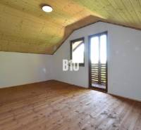 Attic room with wooden paneling and flooring in the Cottage near Bytča.