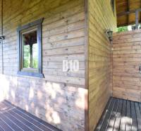 A wooden cottage with a terrace in Bytča, surrounded by nature and sunlight.