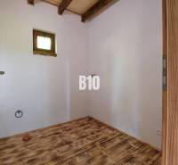 Wooden floor and doors in the interior of a cabin with a skylight.