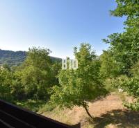 View from the cottage in Bytča with forests and blue sky.