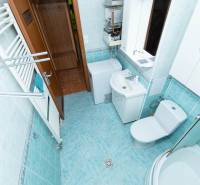 Bathroom in a 2-room apartment with a washing machine, shower, sink, and mirror.