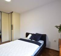 Bedroom in a 2-room apartment with a bed, wardrobe, and wooden dresser.
