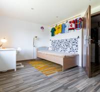 Children's room in a family house with a bed, a desk, and football jerseys on the wall.