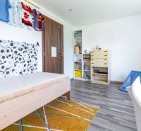 Children's room with a bed, cabinets, and sports jerseys in a family house.