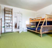 Children's room in a family house with a bunk bed, wall bars, and storage space.