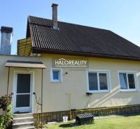 A family house in Župkov with a metal roof, a garden, and two chimneys.