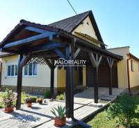 A family house in Župkov with a charming garden, a wooden shelter, and trees in the surroundings.