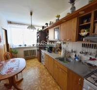 A kitchen in a family house with a wooden cabinet, table, and decorative placemats.
