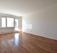 A room in a 4-room apartment with a wooden floor and a large window.