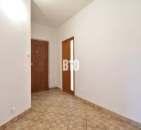 A hallway with ceramic tiles and white walls in a 4-room apartment.