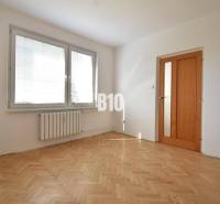 A room with parquet floors and windows with blinds in a 4-room apartment.
