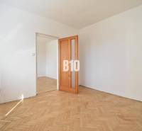A room in a 4-room apartment with a parquet floor and wooden doors.