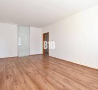A spacious room with laminate flooring and sliding doors in a 4-room apartment.