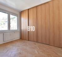 A room in a 4-room apartment with a wooden floor, built-in wardrobe, and a view of the exterior.