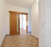 Entrance hallway with sliding doors and tiles in a 4-room apartment.