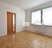 A room in a 4-room apartment with parquet flooring and a large window.