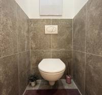 Bathroom with a concealed cistern toilet and gray ceramic tiles in a 3-room apartment.
