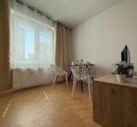 Dining area with a table, chairs, and a cabinet in a 3-room apartment.