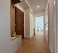 A hallway in a 3-room apartment with a wooden floor and a built-in wardrobe.