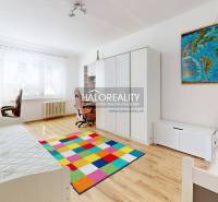 Children's room in a 3-room apartment with a colorful carpet and a desk.