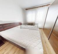 A bedroom in a three-room apartment with a built-in wardrobe and a large window.