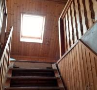 A staircase with wooden paneling and a skylight in a family house.