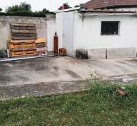The yard at the family house in 2473 Potzneusiedl with a concrete surface and wooden pallets.