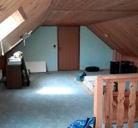 The attic of a family house with wooden paneling and skylights.