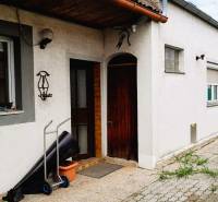 A family house in 2473 Potzneusiedl with a white facade and wooden entrance door.