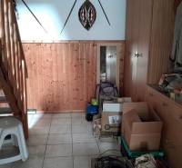 Wooden staircase and storage space in a family house with boxes and coats.