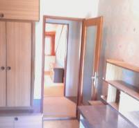 A room in a family house with built-in wardrobes, shelves, and a retro picture.