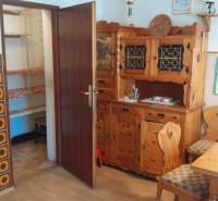 Wooden furniture in the interior of a family house with ornamental wall cladding.