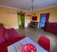 A living room in a family house with red furniture and a colorful table.