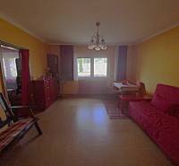 Living room in a family house with colorful walls, a sofa, and a window with a view.