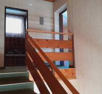 The interior of a hallway with stairs and doors leading to various rooms.