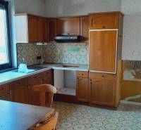 Wooden kitchen unit with tiles and table, Apartment construction.