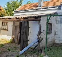 An older farm building in the yard during the construction of apartments in Jois.