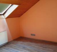 Attic room with a window and radiator, suitable for apartment construction.